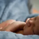 New born baby lying on a blanket.