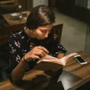A woman reading a book in a cafe.