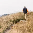 A man walking on a dirt trail.