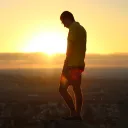 Um jovem de pé numa colina com vista duma aldeia.