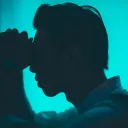 A man with his head leaning against a wall.