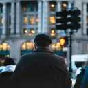 A older man at busy sidewalk.