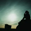 A man sitting on a rock.