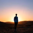 A young man watching the sun set.