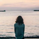 A young woman looking out at a body of water.