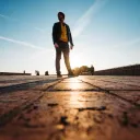 A man walking on a cobblestone sidewalk.