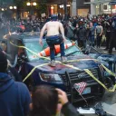 Rioters destroy a police vehicle in Seattle.