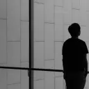 A person looking past a large glass window.