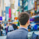 A business man walking in a busy city.