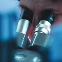 A scientist using a microscope.