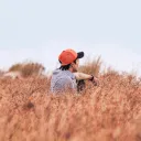 A young man sitting in a field.