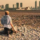 A person sitting on dry barren dirt.