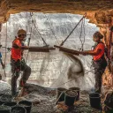Israeli archeologists Hagay Hamer and Oriah Amichai sift dirt at a cave in the Judean Desert where addtional ancient scroll fragments were found.
