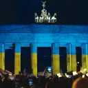 German protestors demonstrate in solidarity with Ukraine in front of the famous Brandenberg gate in Berlin, which is bathed in the colors of the Ukrainian flag.