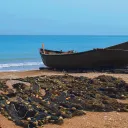 A boat on a sandy shore with nets.