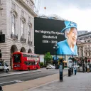 An electronic billboard stating "Her Majesty The Crown - Elizabeth II - 1926-2022
