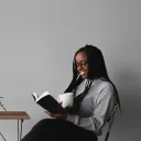 a woman holding a coffee cup and reading a Bible