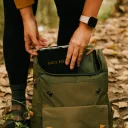 A person pulling their Bible out of the backpack.