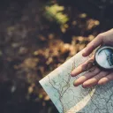 A person holding a compass and a map.