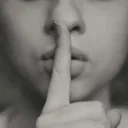 a woman with a finger to her lips in a gesture for silence