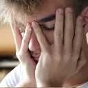 a young man with his head in his hands