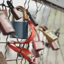 Several padlocks locked on a chain link fence.
