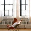 Chair in front of two big windows.