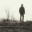 A young man walking in a foggy forest.
