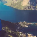 A young woman on top of a mountain looking at a lake.