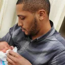 A new dad holding his baby.