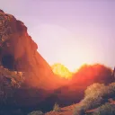 Sun setting behind rocks