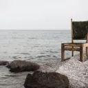 A chair sitting by a lake.