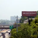 Red "why were you born?" billboard near downtown Cincinnati.