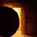 A round stone in front of a tomb entrance.