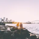 People sitting out rocks near the water.