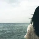 A woman looking at a body of water.