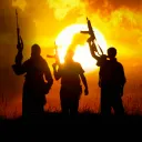 Three men holding machine guns in the air.