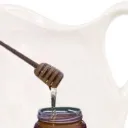 Old milk jar with a honey jar in front.