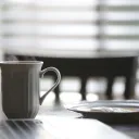 Coffee cup and plate on a table.