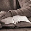 An older person reading a Bible.