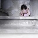 A little girl sitting on a concrete step.