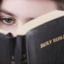 A woman looking at a Bible.