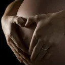 Woman holding pregnant belly.