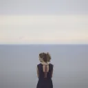 A young women looking at the ocean.