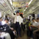 A man surrounded by people on a subway car.