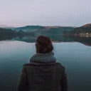 A young woman looking over a lake.