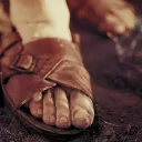 Dirty feet inside a pair of old sandals.
