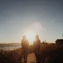 Two women walking toward a beach.
