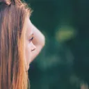 A woman looking with hand her hand by her head.