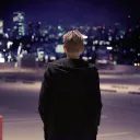 A person walking in a dark parking lot.